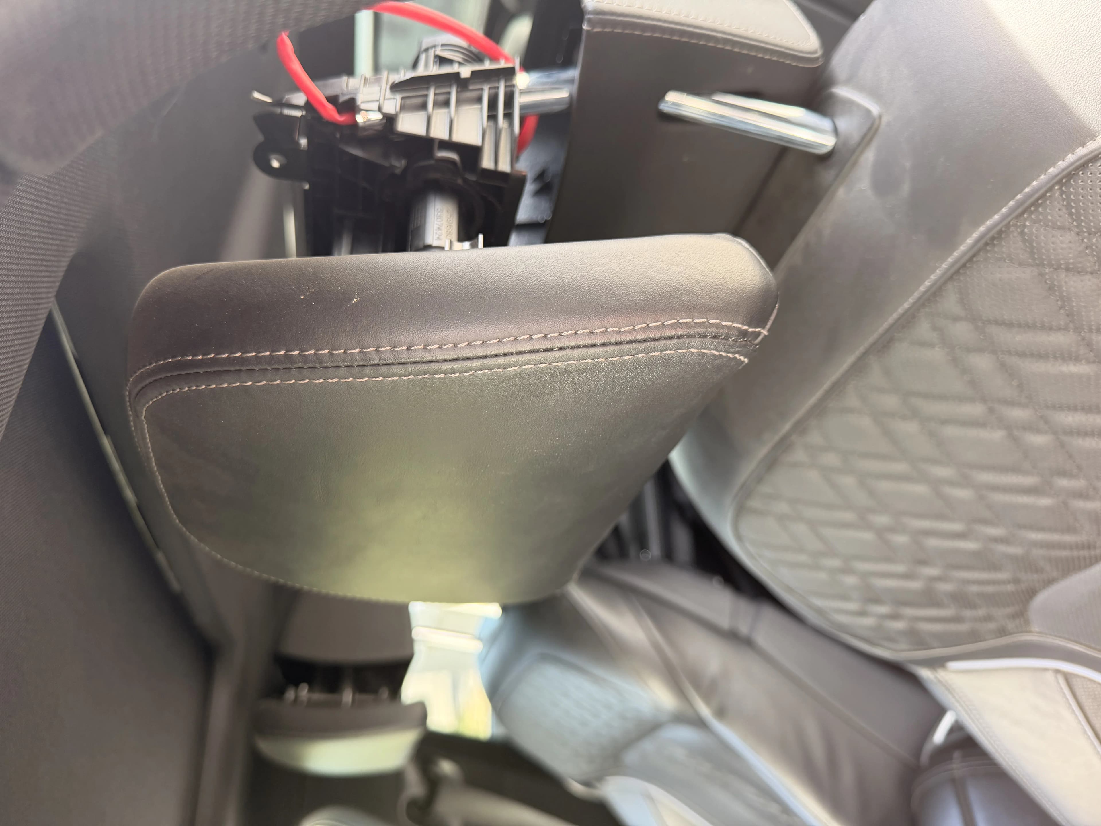 Wnętrze kabiny BMW G12 podczas Sesji 2 — przygotowanie do demontażu aktywnych zagłówków, widoczny fragment fotela M Sport i kabel diagnostyczny